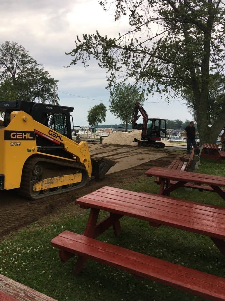 Construction equipment near lakeside picnic area.