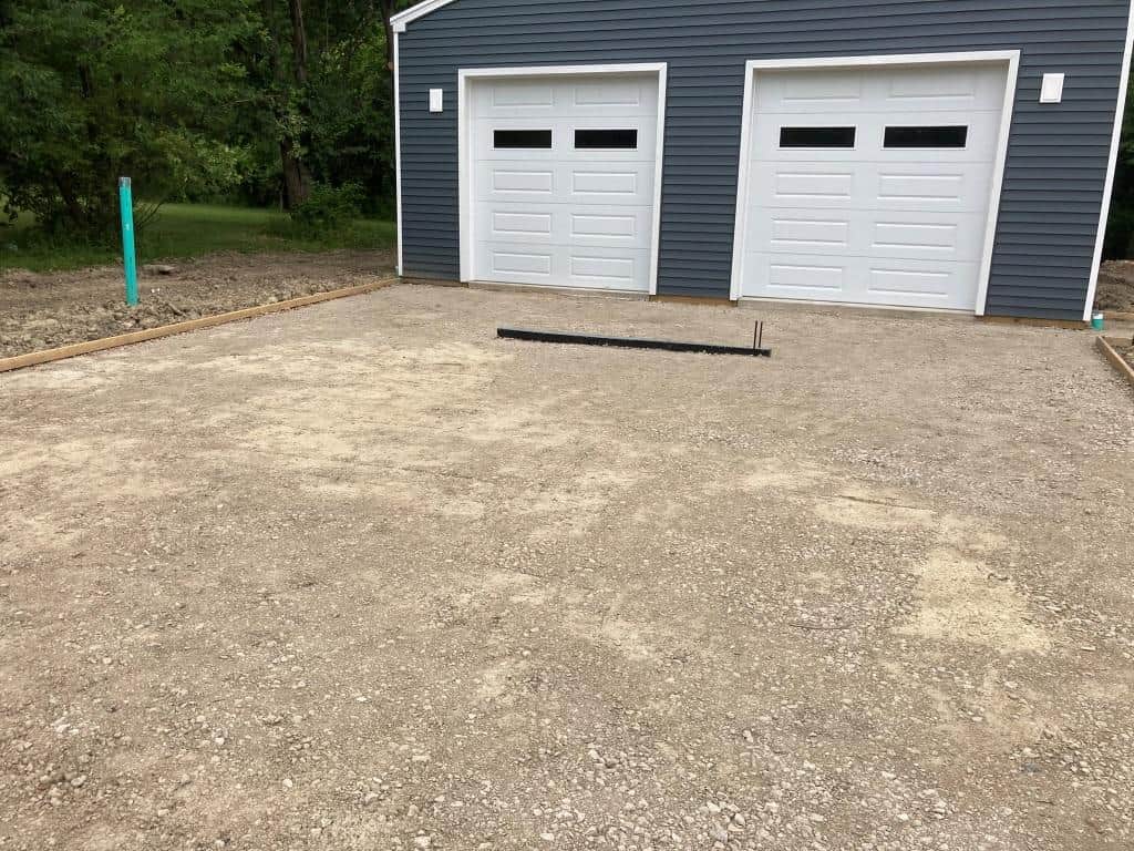 Gravel driveway with garage doors visible