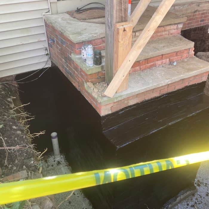 Waterproofed foundation with caution tape