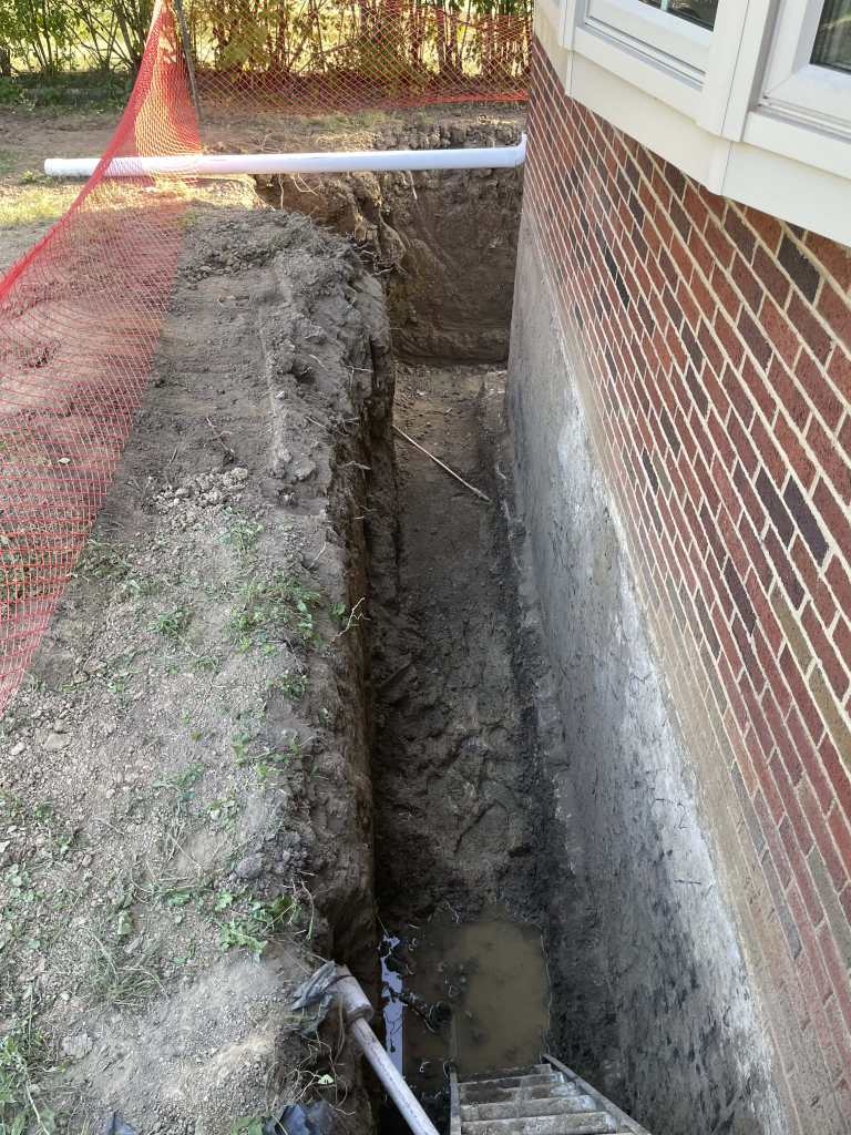 Excavated trench next to a foundation