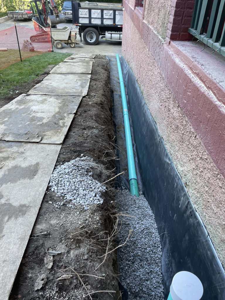 Gravel and drainage pipe installation visible