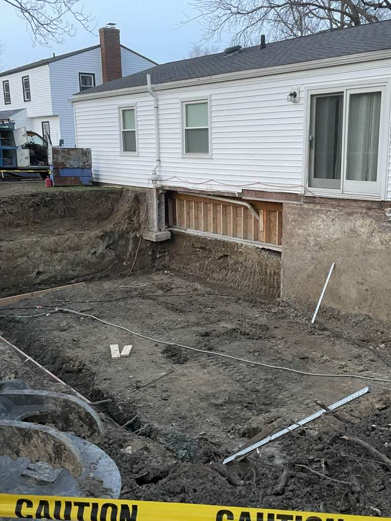 Excavated area next to house foundation