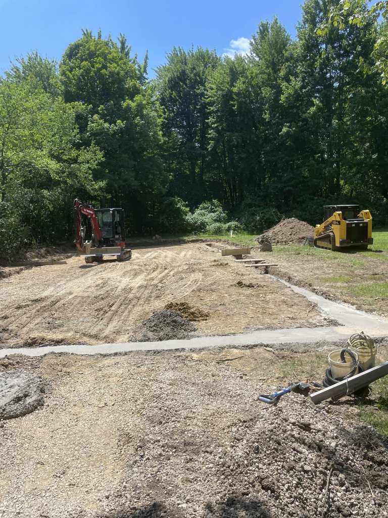 Construction site with machinery and gravel.
