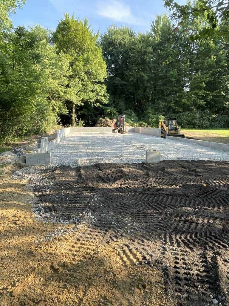 Gravel foundation preparation with machinery.