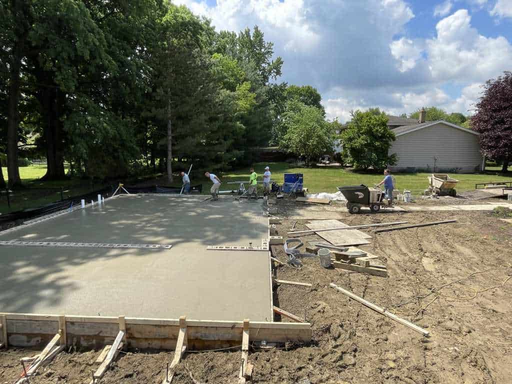 Workers pouring concrete foundation slab