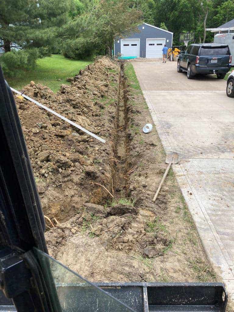 Excavated trench along a driveway.