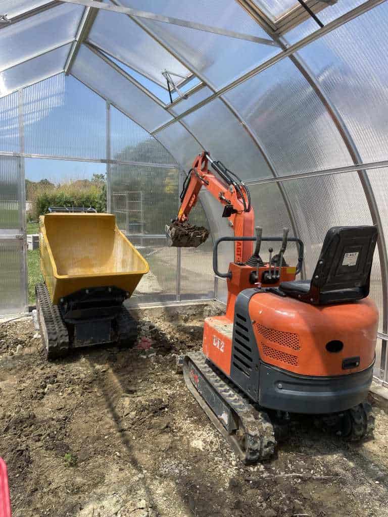 Excavator and dumper in greenhouse