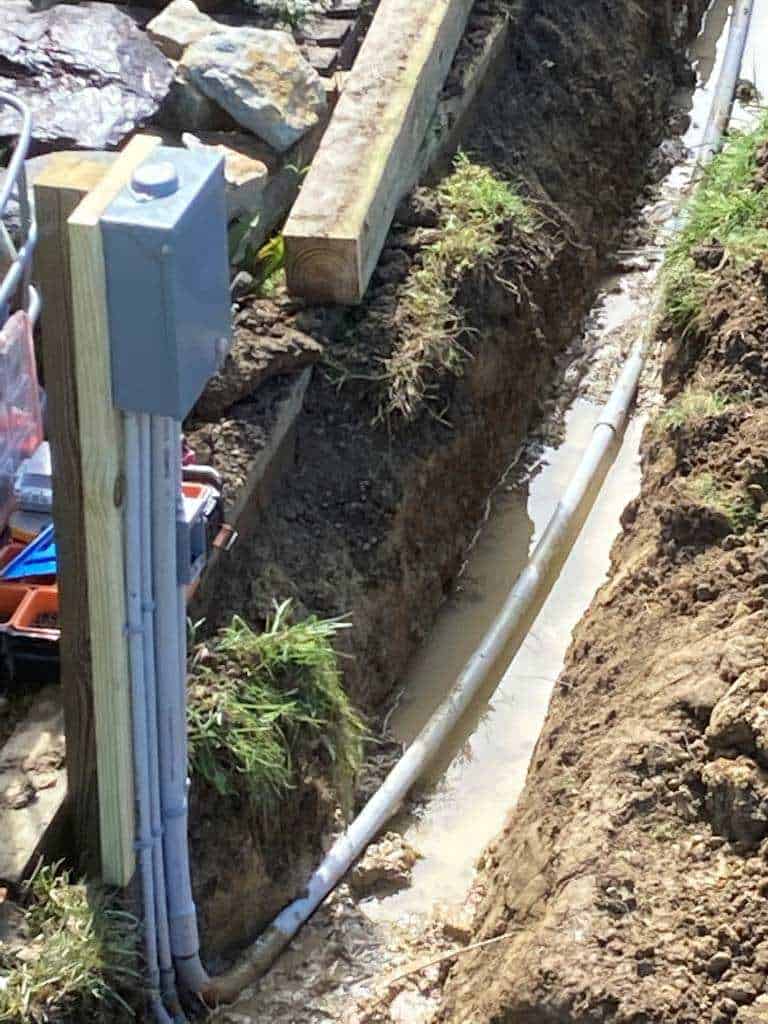 Trench with utility pipes and water