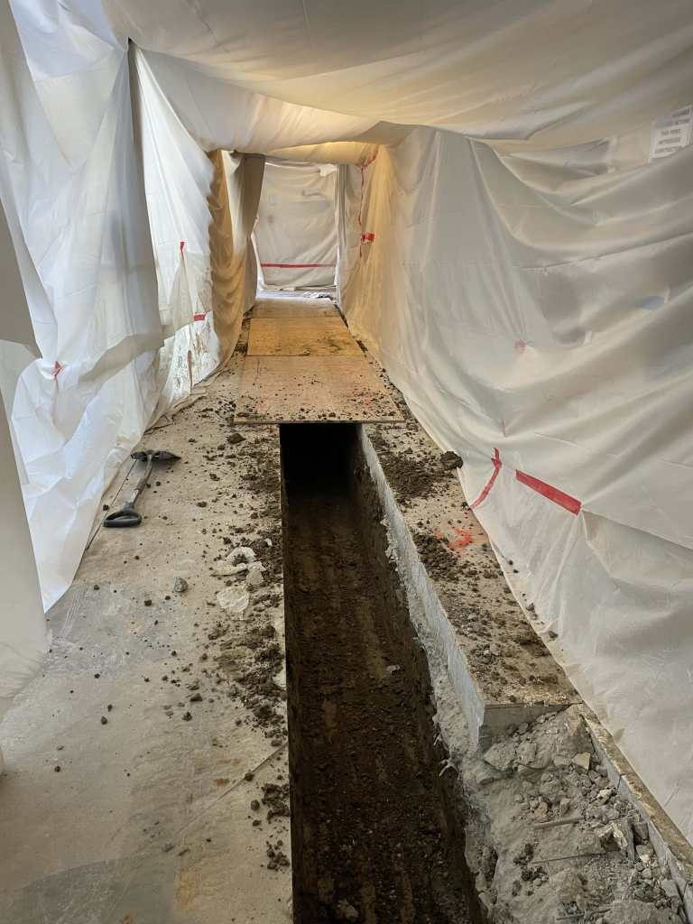 Excavated trench covered with plastic