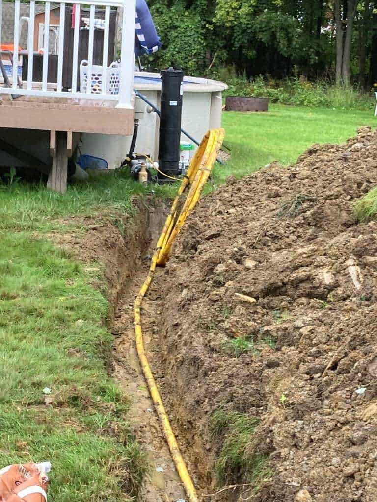 Trench with yellow utility pipe visible