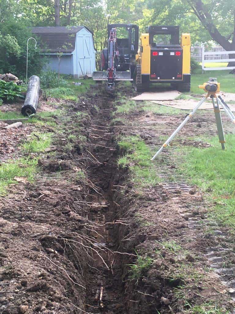 Excavated trench with machinery nearby