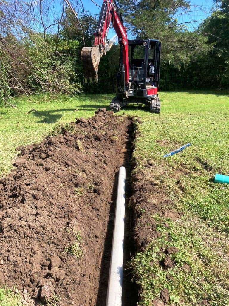 Excavator digging trench for drainage