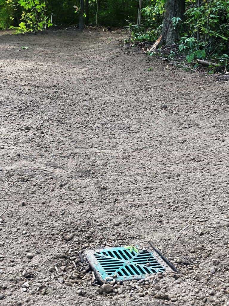 Gravel area with drainage grate visible